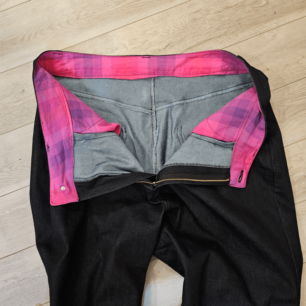 Paire of handmade jeans on the floor showing off the interior.